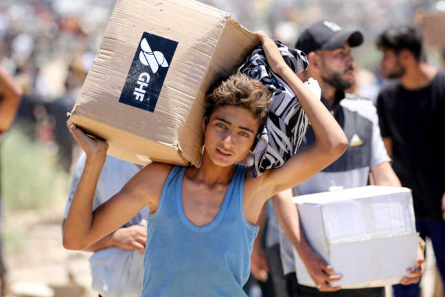 A boy carries a box of relief supplies from a distribution site of the Gaza Humanitarian Foundation, the private, U.S.-backed aid group that has bypassed the longstanding U.N.-led system in the territory. - AFPpix