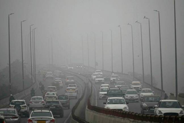 Commuters drive amid dense smog in New Delhi on November 13, 2024. India's capital New Delhi was wreathed in blanketing toxic smog on November 13 as worsening air pollution surged past the grim mark of 50 times World Health Organization recommended daily maximum. - Sajjad HUSSAIN / AFPpix