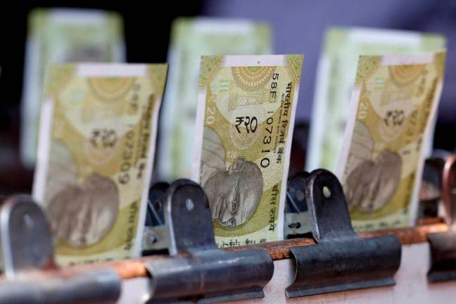 Indian twenty rupee currency notes are displayed at a roadside currency exchange stall in New Delhi, India. -REUTERS