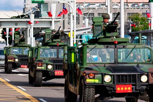 Armed military vehicles patrol outside the Songshan Airport in Taipei on October 14, 2024. China deployed fighter jets and warships to encircle Taiwan on October 14, in drills Beijing said were aimed at sending a “stern warning” to “separatist” forces on the self-ruled island. Taiwanese President Lai Ching-te vowed Monday to “protect democratic Taiwan, and safeguard national security”, while the defence ministry said it dispatched “appropriate forces” in response to the drills. - Daniel CENG / AFP