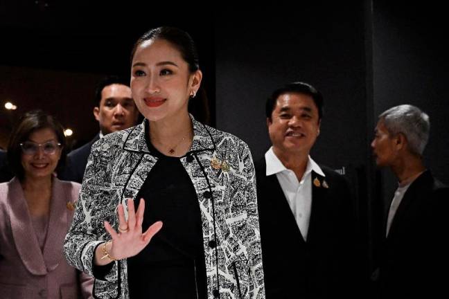 Puea Thai Party leader Paetongtarn Shinawatra, known by her nickname “Ung Ing” and the youngest daughter of former prime minister Thaksin Shinawatra, waves as she leaves a press conference with coalition party leaders after being named the candidate to be Thailand’s next prime minister at Shinawatra Tower in Bangkok on August 15, 2024. Thailand’s Pheu Thai party chose Paetongtarn Shinawatra, the daughter of billionaire ex-PM Thaksin, as its candidate for prime minister, it said August 15, a day after a court dismissed the incumbent premier in an ethics case. - Lillian SUWANRUMPHA / AFPpix