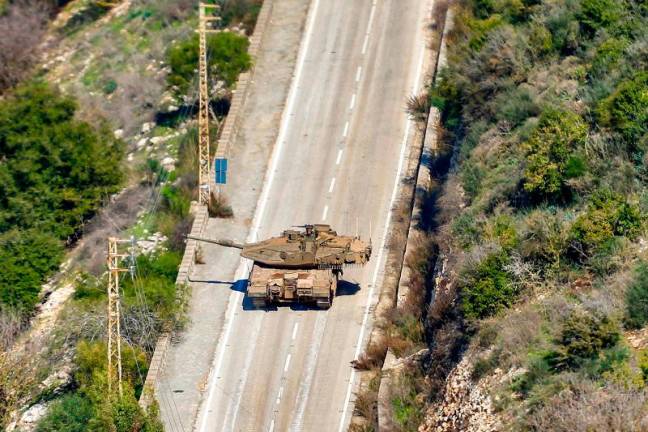 This picture taken from Lebanon’s southern village of Shaqra on January 25, 2025 shows an Israeli army Merkava main battle tank moving along a road at the entrance of the village of Hula along the border with Israel in south Lebanon. - AFPpix