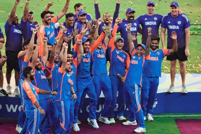 India’s captain Suryakumar Yadav (2R) playfully pretends to hold up the trophy as his team celebrates their victory at the end of the Asia Cup 2025 Twenty20 international cricket final match between India and Pakistan at the Dubai International Stadium in Dubai on September 28, 2025. - AFP