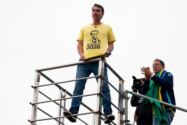 Brazil’s senator Flavio Bolsonaro, son of Brazil’s former president (2019-2022) Jair Bolsonaro, on trial for his alleged role in an attempted coup, wears a T-shirt with an image of his father in a demonstration during Independence Day, at Copacabana beach in Rio de Janeiro, Brazil on September 7, 2025. - AFP