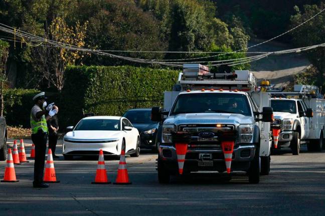 Police direct motorists at a checkpoint on Sunset Boulevard as the Palisades fire continues to burn nearby in Los Angeles, California, on January 9, 2025.