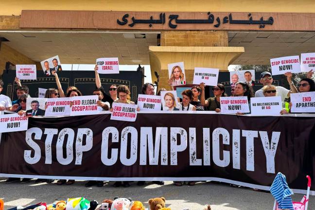 Italian and European parliament members hold placards during a protest in front of the Egyptian side of the Rafah border crossing, calling for an end to the war and for aid to be allowed into the Gaza Strip, on May 18, 2025. - AFPpix