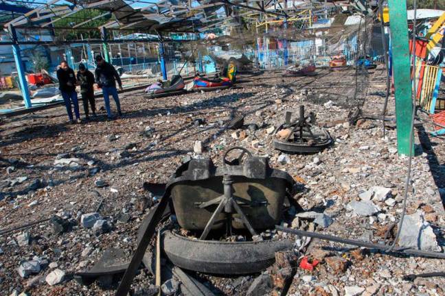 People inspect the damage at an amusement park that was hit in an Israeli airstrike a day earlier, in southern Lebanon's Nabatiyeh el Faouqa village on January 29, 2025. Israeli strikes wounded 24 people in south Lebanon on January 28 despite a ceasefire in force for more than six weeks, the Lebanese health ministry said. - Mahmoud ZAYYAT / AFP