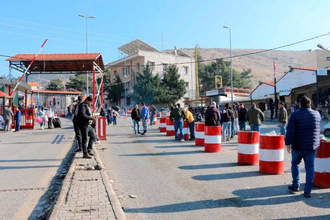 People wait at the entrance of the Al-Masnaa eastern Lebanese border crossing with Syria on January 3, 2025, after Syria imposed new restrictions on the entry of Lebanese citizens. Syria has imposed new restrictions on the entry of Lebanese citizens, two security sources from Lebanon told AFP on January 3, following what the Lebanese army said was a border skirmish with armed Syrians. Lebanese nationals had previously been allowed into Syria without a visa, using just their passport or ID. - Hassan JARRAH / AFP