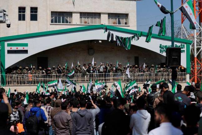 People gather during a demonstration marking the 14th anniversary of the start of the Syrian conflict, in Idlib, Syria.REUTERSpix.