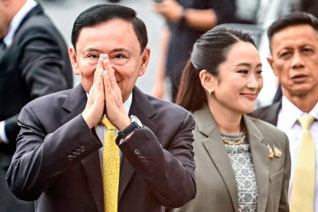 Thailand’s former Prime Minister Thaksin Shinawatra arrives with his daughter Thailand’s sacked prime minister Paetongtarn Shinawatra (R) at the Supreme Court in Bangkok on September 9, 2025. - AFP