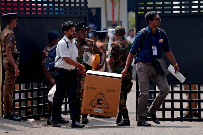 Polling officials and police officers carry election materials after collecting them from a distribution centre, a day before the Parliamentary Election, in Colombo, Sri Lanka, November 13, 2024. - REUTERS/Thilina Kaluthotage