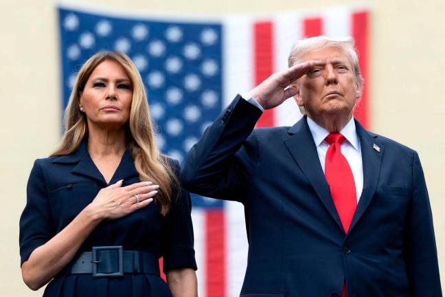 U.S. President Donald Trump salutes during the playing of “Taps” with first lady Melania Trump during a September 11th observance event in the courtyard of the Pentagon September 11, 2025 in Arlington, Virginia. Today marks the 24th anniversary of the 9/11 terror attacks that claimed the lives of nearly 3,000 people. Win McNamee/Getty Images/AFP (Photo by WIN MCNAMEE / GETTY IMAGES NORTH AMERICA / AFP)