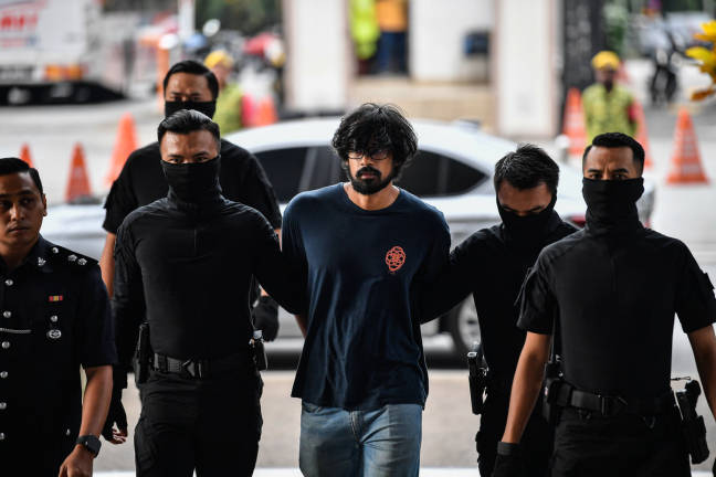 Former research assistant of a politician Muhammed Yusoff Rawther, 31, (center) was charged in the Magistrate’s Court with trafficking 305 grams of cannabis. - BERNAMApix