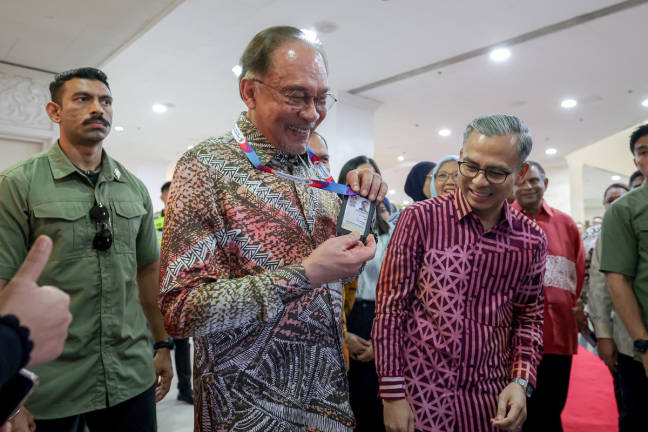Prime Minister Datuk Seri Anwar Ibrahim showed the media pass presented by Communications Minister Datuk Fahmi Fadzil while attending the HAWANA 2025 Summit at the Kuala Lumpur World Trade Centre (WTCKL) today. - BERNAMApix