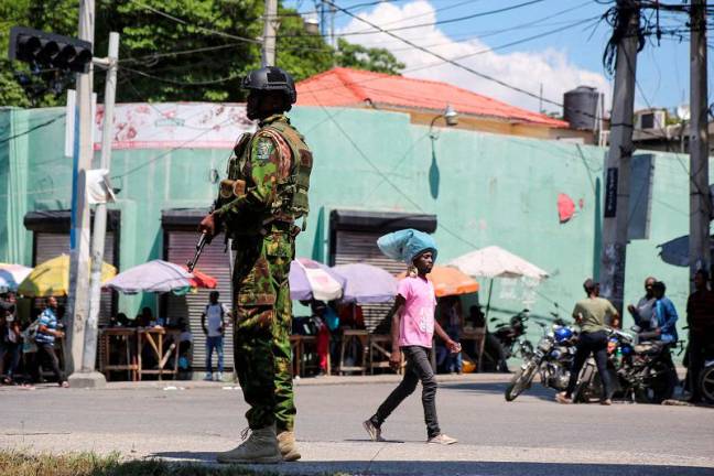 A Kenyan police officer patrols as the country is facing emergency food insecurity while immersed in a social and political crisis, in Port-au-Prince, Haiti October 3, 2024. - REUTERS / Jean Feguens Regala / File Photo