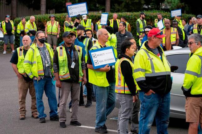 Boeing factory workers hold signs as they wait in line to vote on their first full contract in 16 years, at an International Association of Machinists and Aerospace Workers District 751 union hall, in Renton, Washington, U.S. September 12, 2024. - REUTERS/David Ryder