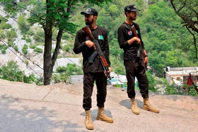 Police officers stand guard on a road leading to Bilal Mosque after it was hit by an Indian strike in Muzaffarabad, the capital of Pakistan-administered Kashmir - REUTERSpix