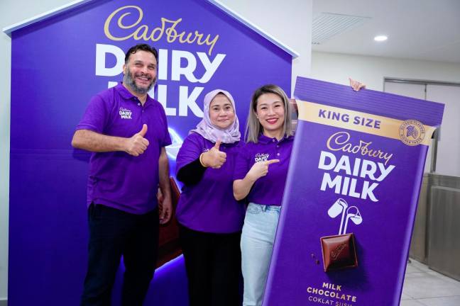 From left: Mondelez International (Malaysia) manufacturing director Abdallah Habib, Mondelez International (Malaysia &amp; Singapore) corporate and government affairs head Raja Zalina Raja Safran and See unveiling the Cadbury King Size 200gm bar in Shah Alam today.