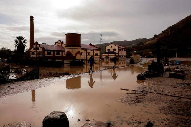 Men walk along a flooded area after heavy rains and floods in Alora, Spain October 29, 2024. - REUTERS/Jon Nazca