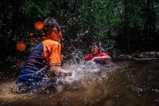 A group of kids cools off in a river due the hot weather in Hulu Yam, Gombak. Six areas in the peninsula recorded a yellow (alert) level heatwave as at 6am today, according to the Malaysian Meteorological Department (MetMalaysia). - theSun file pic