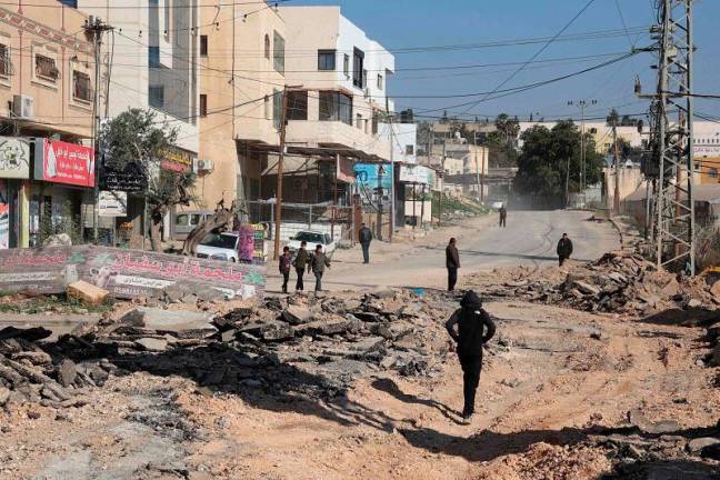 Palestinians inspect a road, which was unearthed during a raid by Israeli forces, in the Fara camp for Palestinian refugees near Tubas in the north of the occupied West Bank on January 7, 2025. - Zain JAAFAR / AFP