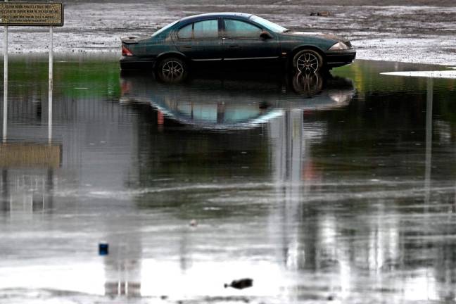 A car sits submerged in flood water along the banks of the Manning River in Taree on May 23, 2025. Record floods cut a destructive path through eastern Australia on May 23, caking houses in silt, washing out roads and separating 50,000 people from help. - AFPpix