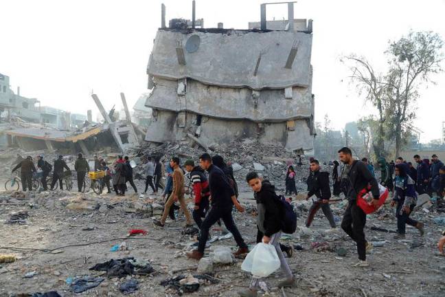 Displaced Palestinians make their way past rubble, as they attempt to return to their homes, following a delay in the ceasefire between Israel and Hamas over the hostage list, in the northern Gaza Strip January 19, 2025. - REUTERS/Khalil Ramzi