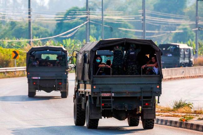 Multinational victims of scam centers, who were tricked or trafficked into working in Myanmar, travel on army trucks after they were sent to Thailand, in Phop Phra District, Tak province, Thailand February 12, 2025. - REUTERS/Krit Phromsakla Na Sakolnakorn