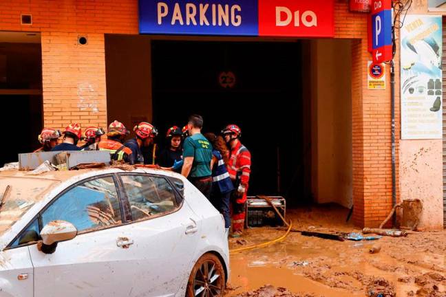 First responders gather at a parking lot during a search for victims after deadly flooding in the Valencia region, in Catarroja, Spain November 1, 2024. - REUTERS/Bruna Casas