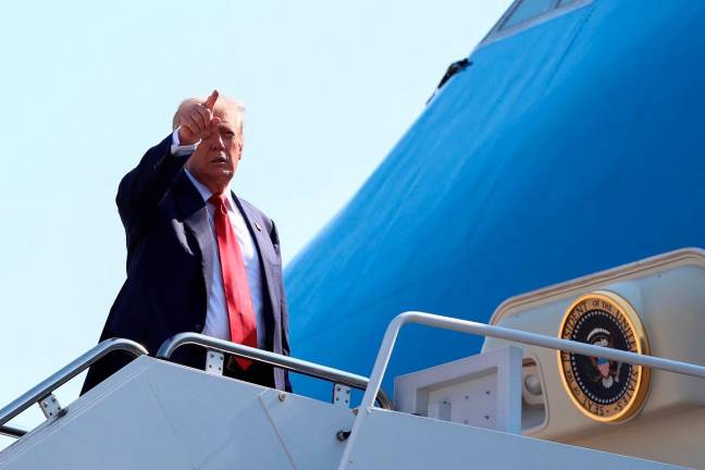 U.S. President Donald Trump gestures while boarding Air Force One, as he departs for Scotland, at Joint Base Andrews, Maryland, U.S., July 25, 2025. - REUTERS