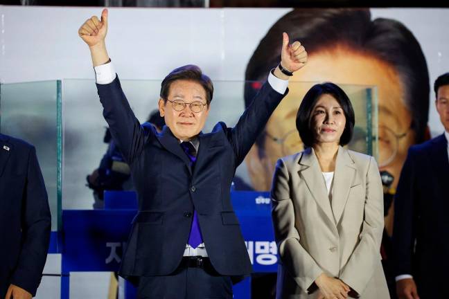 Lee Jae-myung, the presidential candidate for South Korea’s Democratic Party, gestures while standing next to his wife Kim Hye-kyung, as he greets his supporters in front of the National Assembly in Seoul, South Korea, June 4, 2025. - REUTERS/Kim Hong-Ji