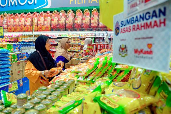 People buy basic necessities at a supermarket using the Sumbangan Asas Rahmah (SARA) assistance of RM100 which was distributed starting yesterday. - Bernama pic