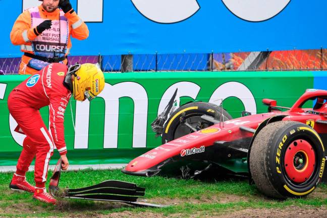Ferrari driver Lewis Hamilton moves a piece of his front wing after crashing during the Formula One Dutch Grand Prix at The Circuit Zandvoort, western Netherlands, on August 31, 2025. - AFP