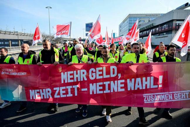 Workers hold a banner as they demonstrate during a 24-hour strike at the Frankfurt Airport called by the German trade union Verdi over a wage dispute in Frankfurt. The banner reads, “More money, more time - my choice! REUTERSpix