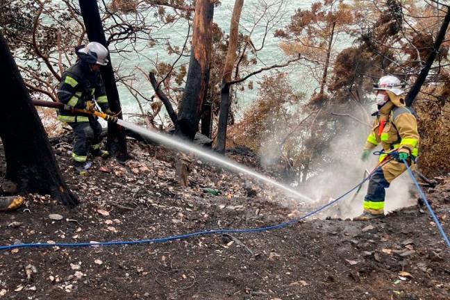 This photo taken and released on March 6, 2025 by Japan's Fire and Disaster Management Agency shows firefighters battling a wildfire in Ofunato city of Iwate Prefecture. Rain appears to have halted the spread of Japan's worst wildfire in more than half a century, officials said on March 6, as residents expressed relief the smoke was gone. - AFP PHOTO / Fire and Disaster Management Agency