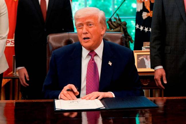 U.S. President Donald Trump signs a joint resolution in the Oval Office at the White House in Washington, D.C., U.S., May 9, 2025. REUTERS/Kent Nishimura