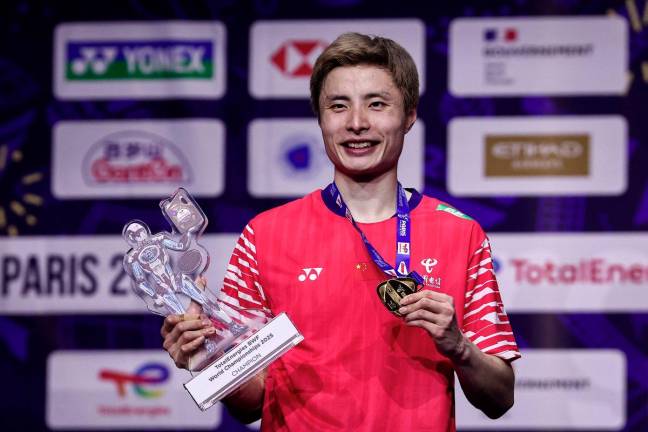 China’s Shi Yuqi celebrates with his trophy on the podium after winning the men’s singles final match against Thailand’s Kunlavut Vitidsarn at the Badminton BWF World Championships at the Adidas Arena in Paris, on August 31, 2025. - AFP