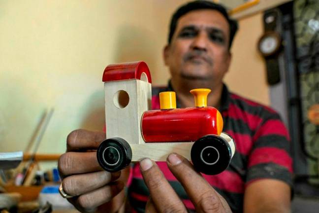 Artisan Kouser Pasha displaying a wooden toy train at his toy factory in Channapatna in the Ramanagara district of India’s Karnataka state. AFPpixS