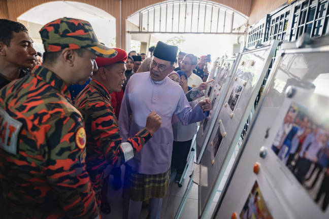 Prime Minister Datuk Seri Anwar Ibrahim conversed with the Director of the Kuala Lumpur Fire and Rescue Department (JBPM), Hassan ‘As’ari Omar (second from left), during his visit to the administration building of Sekolah Menengah Sains Alam Shah in Cheras, which was destroyed in a fire, earlier today. - BERNAMApix