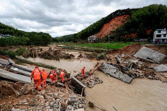 Members of a rescue team walk to a flood-affacted area in Zixing, in central China’s Hunan province on July 29, 2024. Seven people died and three were missing after heavy rain and flooding hit central China’s Hunan province, state media reported on July 30.