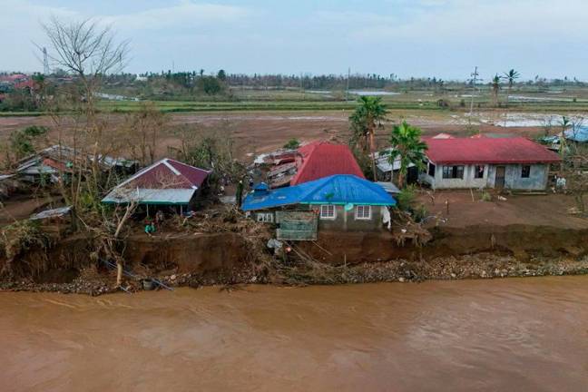 This handout photo taken on November 15, 2024 and received courtesy of the Bloggers of Tuguegarao Facebook page shows an aerial view of damaged houses along a river in Gonzaga town, Cagayan province, a day after Typhoon Usagi hit the province. Typhoon Usagi blew out of the Philippines early on November 15 as another dangerous storm drew closer, threatening an area where scores were killed by flash floods and landslides just weeks ago, the weather service said. - AFP PHOTO / BLOGGERS OF TUGUEGARAO FACEBOOK PAGE