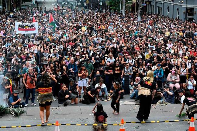 Demonstrators take part in the annual “Invasion Day” protest march through the streets of Melbourne as a group of Indigenous dance on Australia Day on January 26, 2025. Tens of thousands of Australians protested over the treatment of Indigenous people as the country celebrated a national holiday marking the 1788 arrival of British colonisers. - Paul Crock / AFP