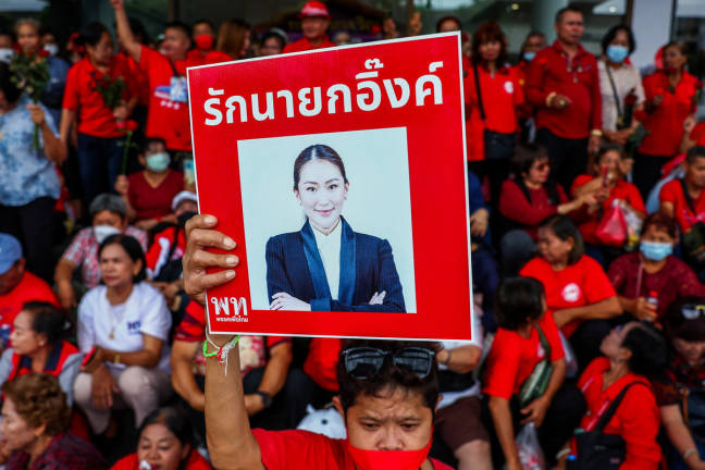 A Pheu Thai supporter holds a placard with a portrait of Thailand’s Prime Minister Paetongtarn Shinawatra as people gather at Pheu Thai Party Headquarter to support Paetongtarn, as she battles to stay in power after drawing sharp criticism of her handling of a border row with Cambodia, in Bangkok, Thailand, June 27, 2025. - REUTERS