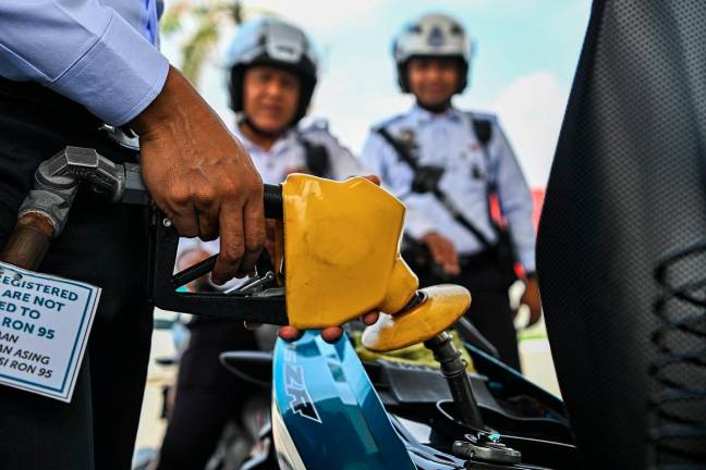 Anggota Penguatkuasaan Trafik IPD Seremban mengisi petrol RON95 di stesen Petronas S2 City Park pada harga RM1.99 seliter, berbanding harga pasaran RM2.05 seliter, menerusi inisiatif BUDI MADANI RON95 (BUDI95) yang bermula semalam. - Bernama