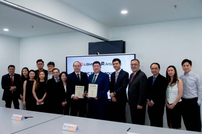 LGMS chairman Fong Choong Fook (middle left) holding the signed agreement with Antarex CEO Tan Pek Loon together with the management team from both companies.