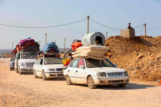 Displaced Palestinians cross a checkpoint manned by US and Egyptian security at the Netzarim corridor on their way from the south to the northern parts of the Gaza Strip, on Salah al-Din road in central Gaza, on January 29, 2025. Columns of Palestinians carrying what belongings they could headed to north Gaza on January 29, for a third straight day, after Israel permitted their passage in accordance with an ongoing ceasefire. - Omar AL-QATTAA / AFP