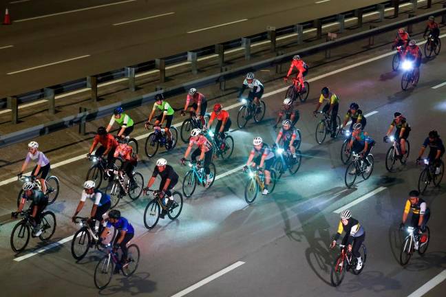 Antara peserta yang menyertai RHB Lekas Highway Cycling Ride 2025 di Lebuhraya Lekas malam tadi. - Bernama