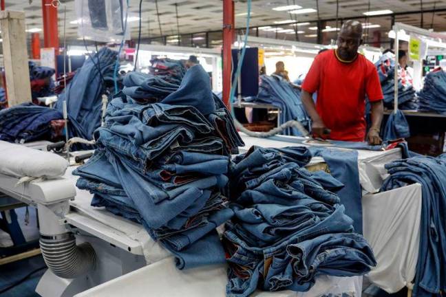 A worker irons pairs of jeans inside the United Aryan textile factory at the Export Processing Zone (EPZ) in Nairobi on February 4, 2025. Photo by SIMON MAINA / AFP