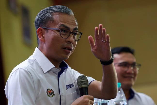Communications Minister Datuk Fahmi Fadzil (left) during a town hall session at the Peninsular MADANI Community Settlement Programme 2025 at the Bistari Mini Stadium in Ayer Keroh today.