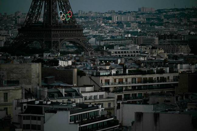 This photograph taken from the Arc de Triomphe shows the Eiffel Towers with the Olympic Rings during the Paris 2024 Paralympic Games Opening Ceremony in Paris on August 28, 2024. - Martin BUREAU / AFP